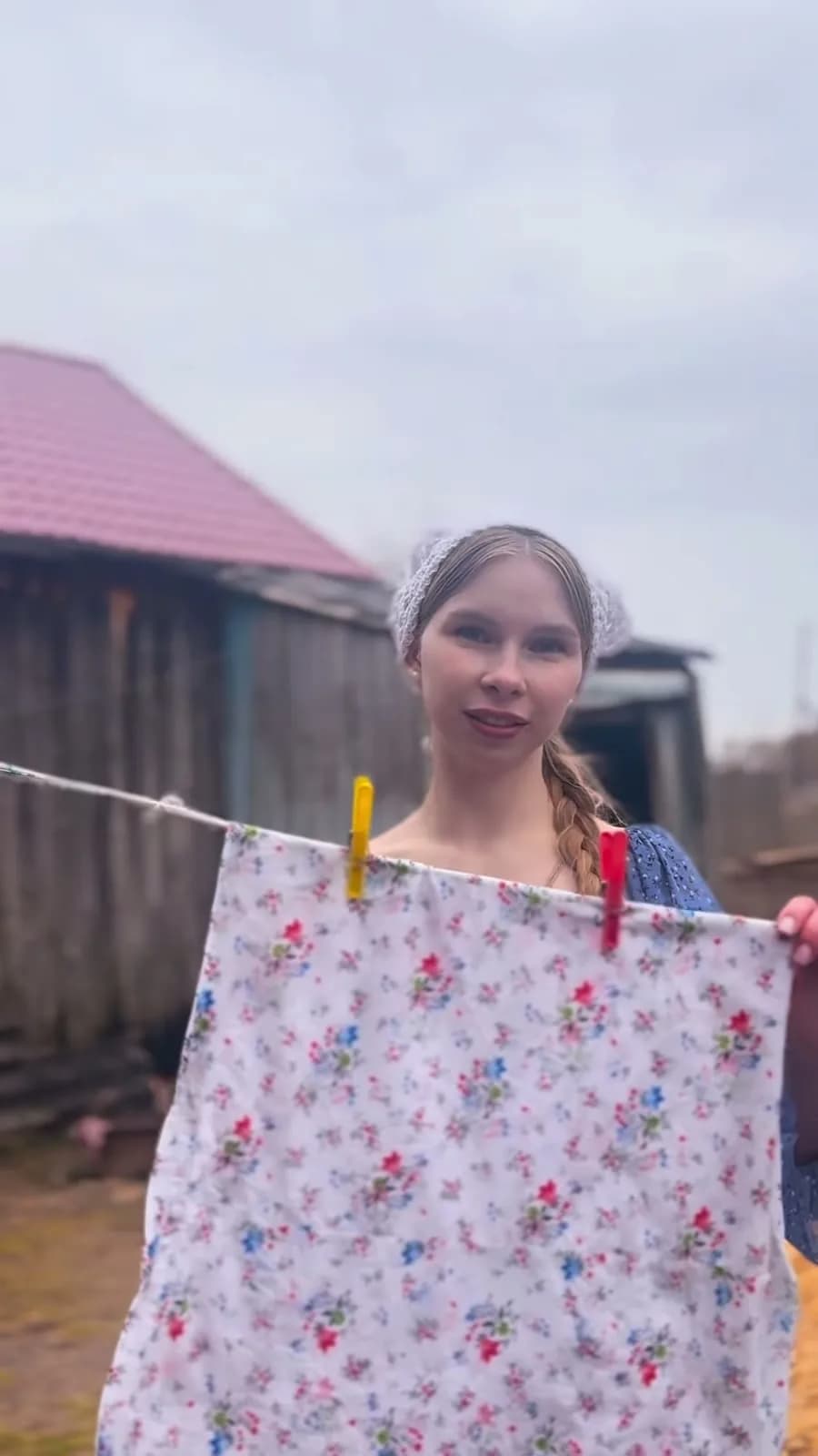 Надя развешивает цветное бельё во дворе